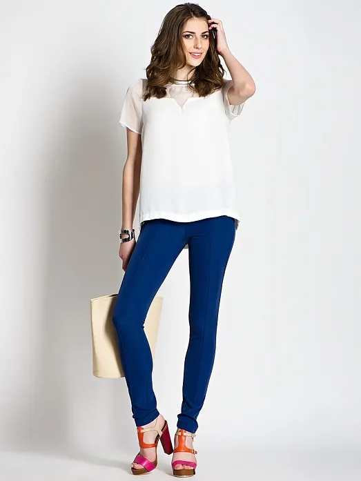 Девушка в темно-синих брюках и белой футболке