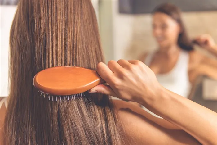 Девушка показывает, как массаж щеткой может быстро убрать волосы