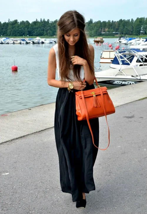 Темная юбка прекрасно подчеркивается яркой сумкой. 