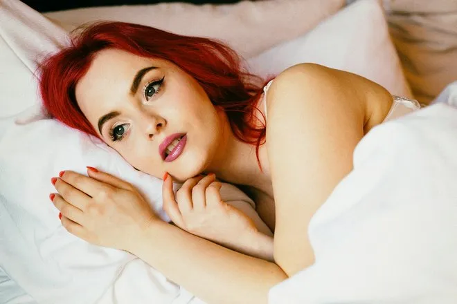 Девушка с белой подушкой и рыжими волосами