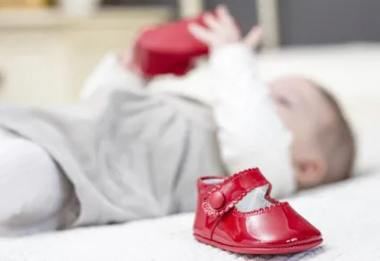 Девушка смотрит на красные сандалии