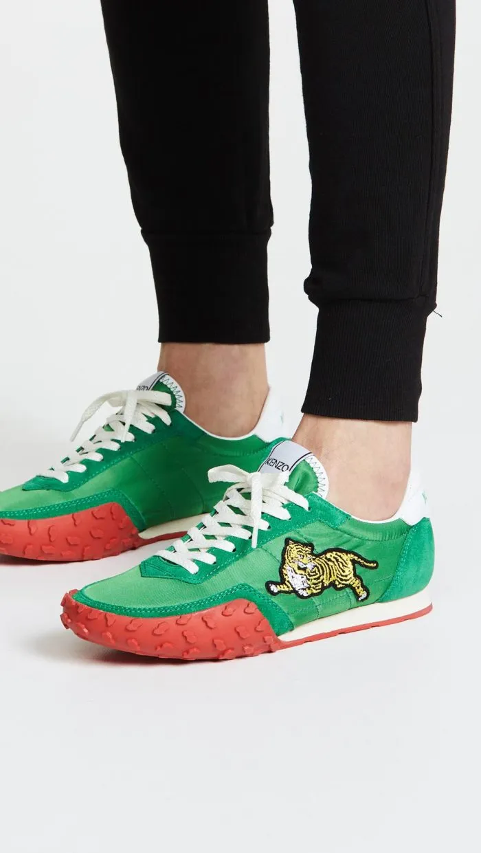 Традиционная обувь весны 2021 года: зеленые кроссовки с украшением.