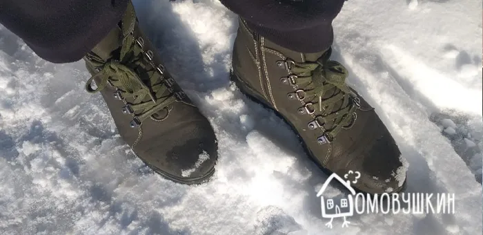 Зимние сапоги и ноги в скользком снегу