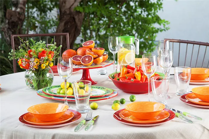 Для летнего декора можно использовать ярко-оранжевые тарелки, вазы с летними фруктами и цветами.