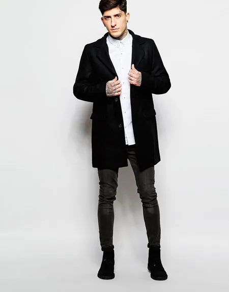 Мужчина в черном пальто и коротких брюках