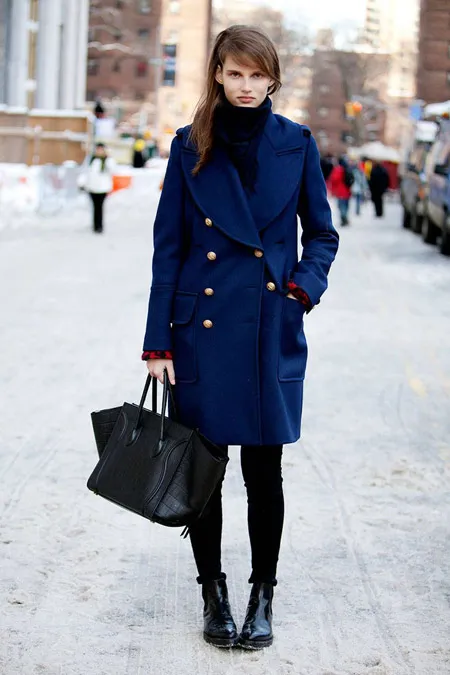 Девушка в синем пальто и с черной сумкой