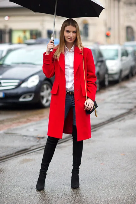 Девушка в высоких сапогах и красном пальто.