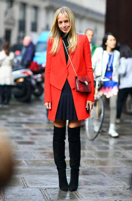 Девушка в красном пальто с плиссированной юбкой