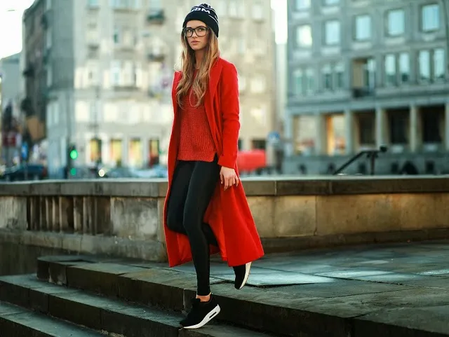 Девушка в черных кроссовках и красном пальто