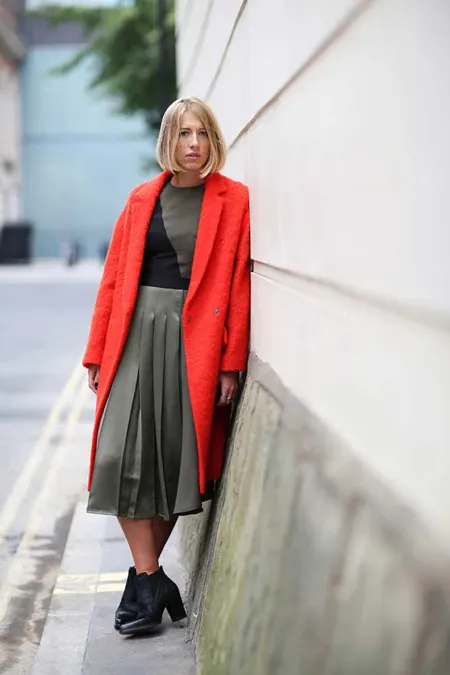 Девушка в юбке средней длины и красном пальто