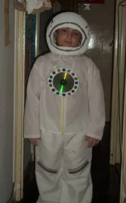 Белый костюм космонавта, украшенный компакт-диском на груди мальчика