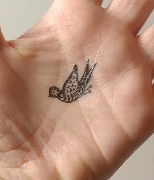 Мини-татуировка черной птицы на ладони