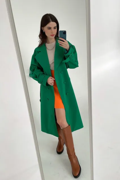 Зеленый тренч из хлопка средней длины с оранжевой юбкой, светлой футболкой и коричневыми сапогами — стильный look для юной модницы: