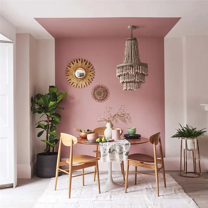 Столовая с окрашенной в розовый цвет частью стены и потолка.