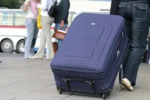мужчина тащит чемодан