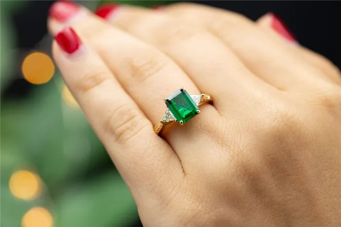 Изумруд с бриллиантами по бокам – классический образ для обручального кольца