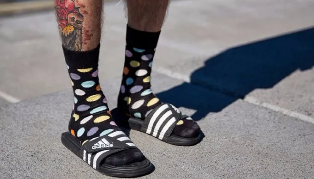 Черные носки с разноцветными кругами в сочетании с черно-белыми мужскими сандалиями.