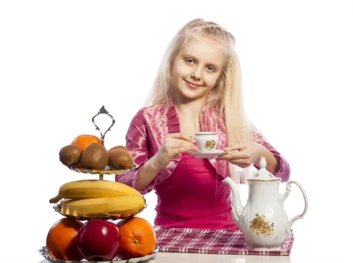 Правила этикета для ребенка - девочка сидит за столом и держит блюдце по правилам этикета