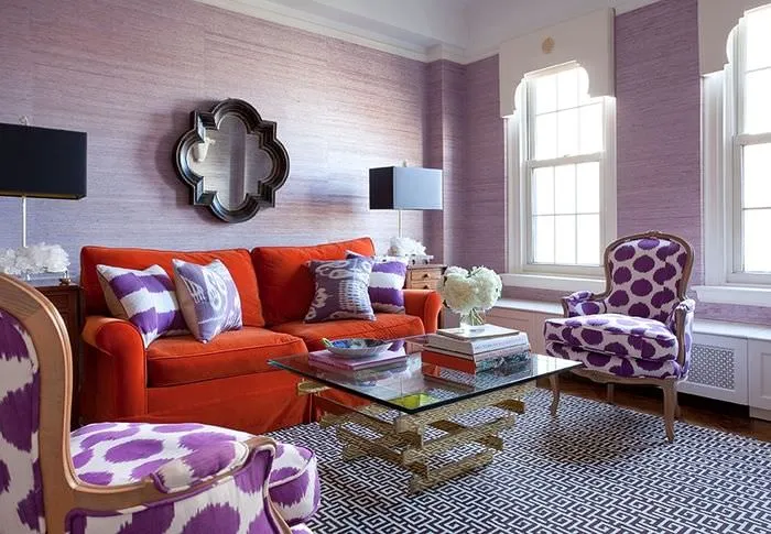 Морковный диван в комнате с лавандовыми стенами